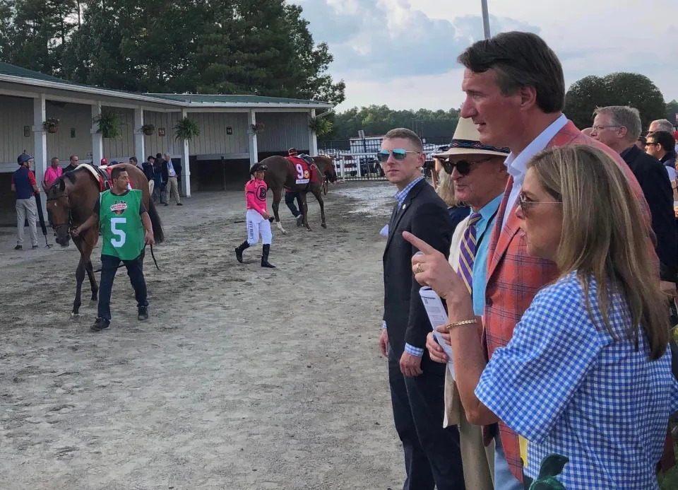 Governor Glenn Youngkin and First Lady Suzanne S. Youngkin try to spot a winner in the paddock at Colonial Downs Racetrack in New Kent, Va. on Saturday, August 12 during 'Festival of Racing."